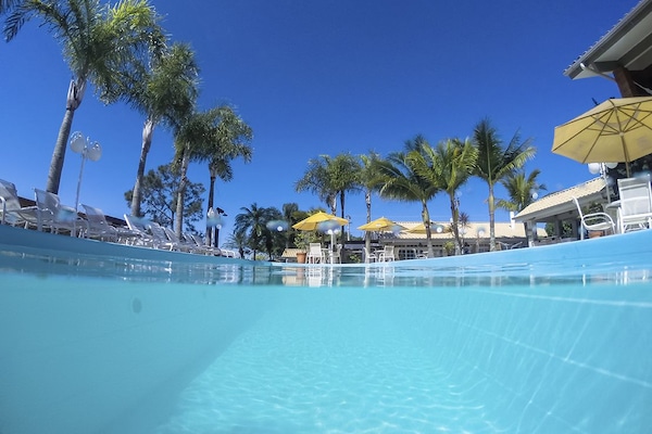 Una piscina al aire libre, sillones reclinables de piscina