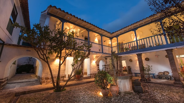 A courtyard with a covered patio, stone walls, and potted plants. - Inkarri Cusco (Cusco)