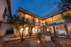 A courtyard with a covered patio, stone walls, and potted plants. - Inkarri Cusco (Cusco)