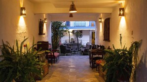 A cozy, well-lit interior with a stone floor, wooden furniture, and potted plants. - Inkarri Cusco (Cusco)