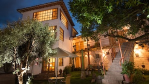 A two-story building with a courtyard, featuring a staircase, outdoor seating, and potted plants. - Inkarri Cusco (Cusco)
