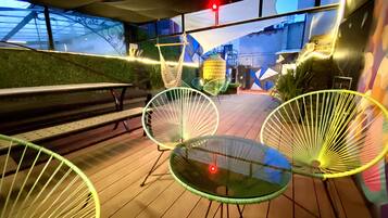 An outdoor seating area with metal chairs and a bench.