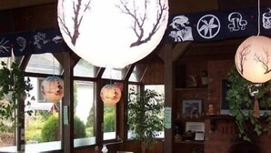 A room with large windows, hanging paper lanterns, and a wooden ceiling. - Timberlodge RV & Campground (Port Alberni)
