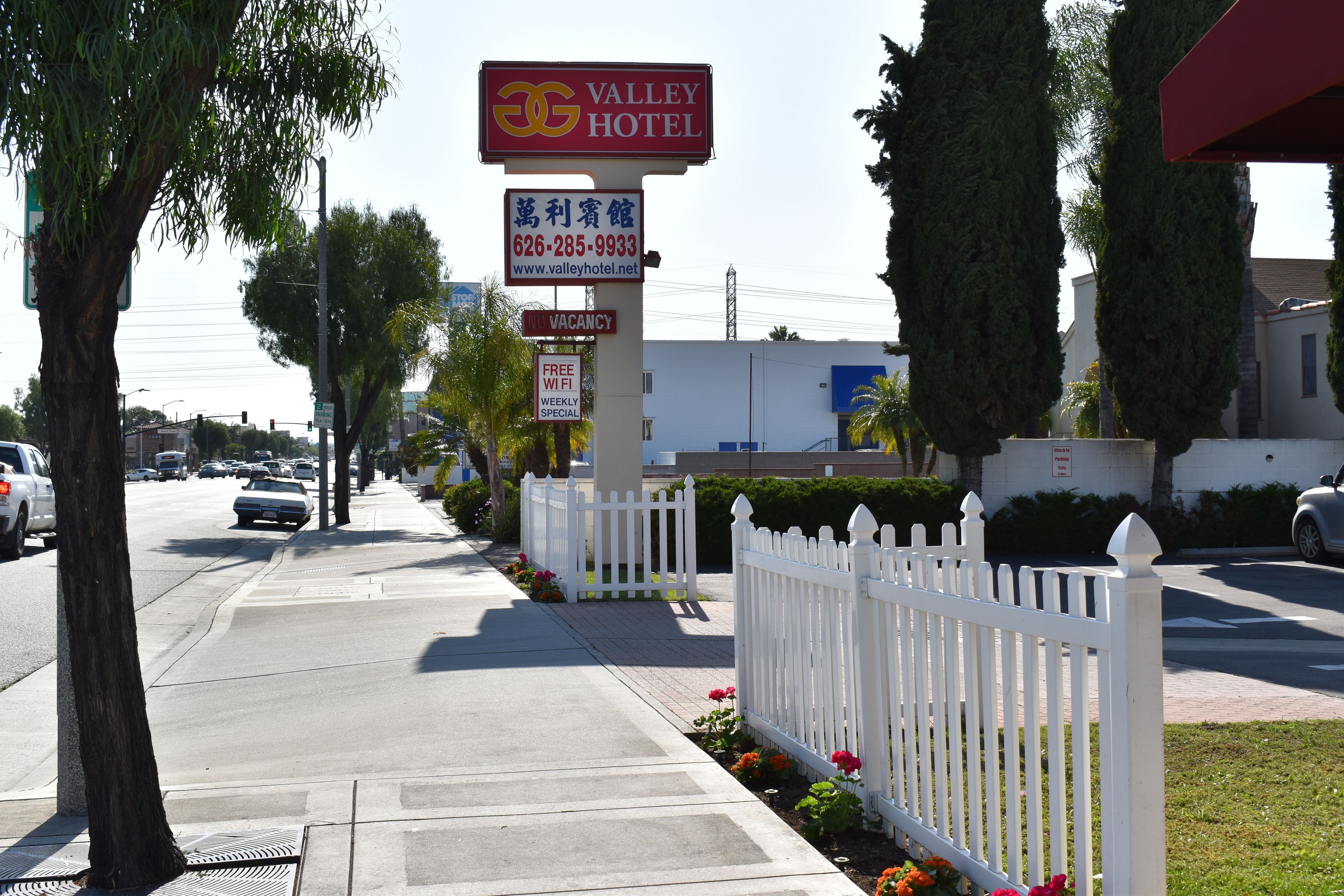 A hotel sign with a contact number and website, a 'VACANCY' sign, and a 'FREE WIFI' sign.