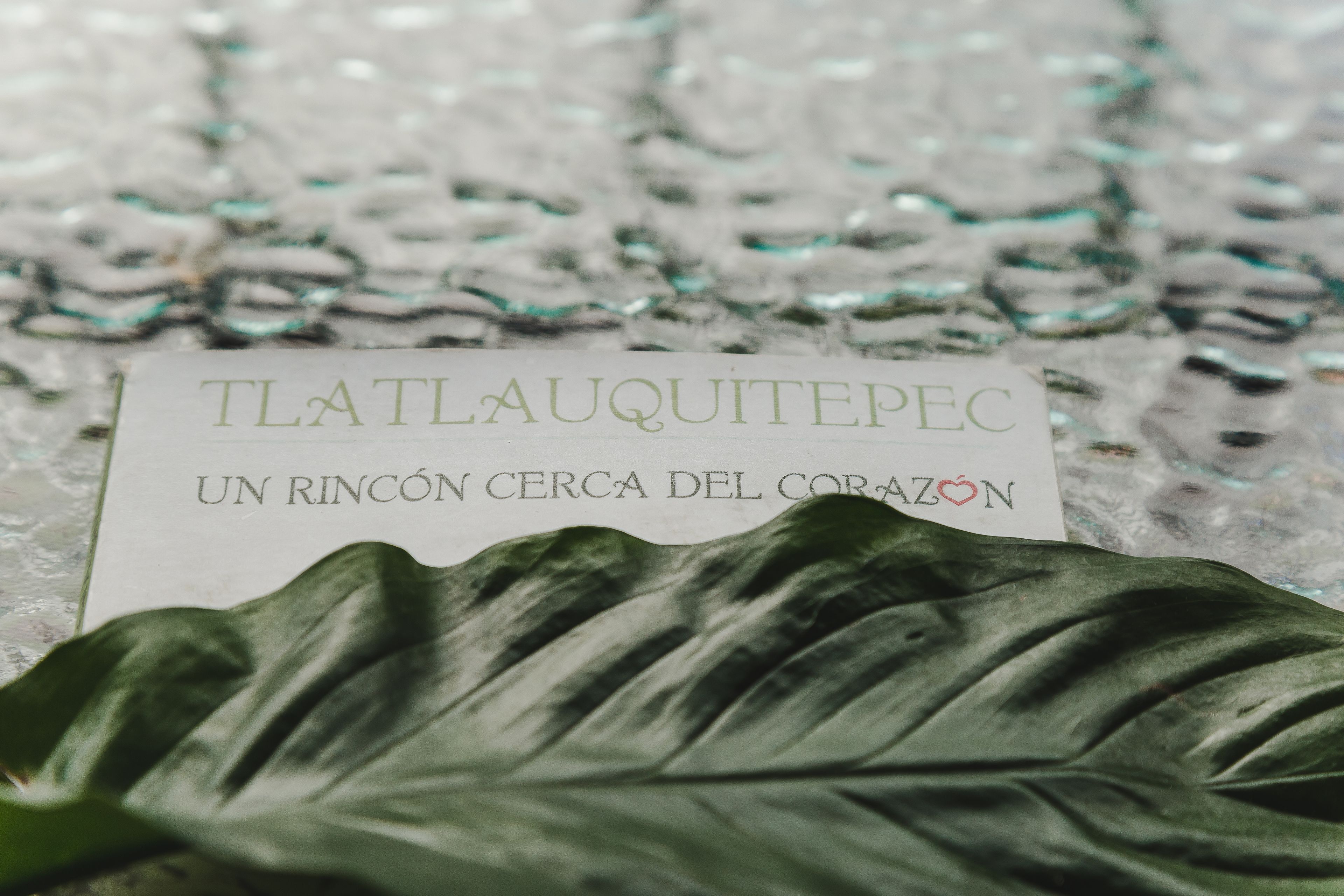 Eine Karte mit dem Text „TLAQUITEPEC“ und „UN RINCÓN CERCA DEL CORAZÓN“ auf einer strukturierten Oberfläche.