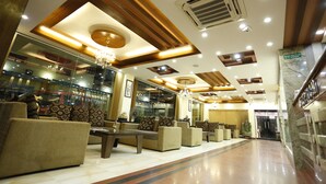 A hotel lobby with sofas, a chandelier, and a marble floor. - Mahadev Hotel (Kathmandu)
