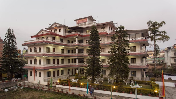 A multi-story hotel with balconies, outdoor seating, and potted plants. - Hotel Norbu Sangpo (Kathmandu)