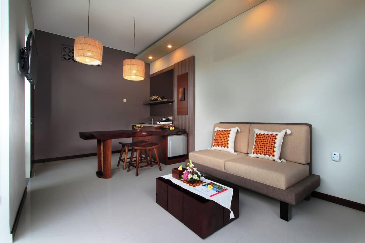 Una sala de estar moderna con sofá, mesa de centro, comedor y cocina.