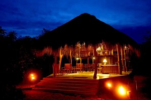 A thatched-roof structure with outdoor seating and a bar area, surrounded by vegetation. - The Yala Adventure (Thissamaharama)