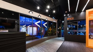 A modern hotel lobby with a reception desk, large windows, and a sign for the Box Design Hotel. - Taichung Box Design Hotel (Taichung)