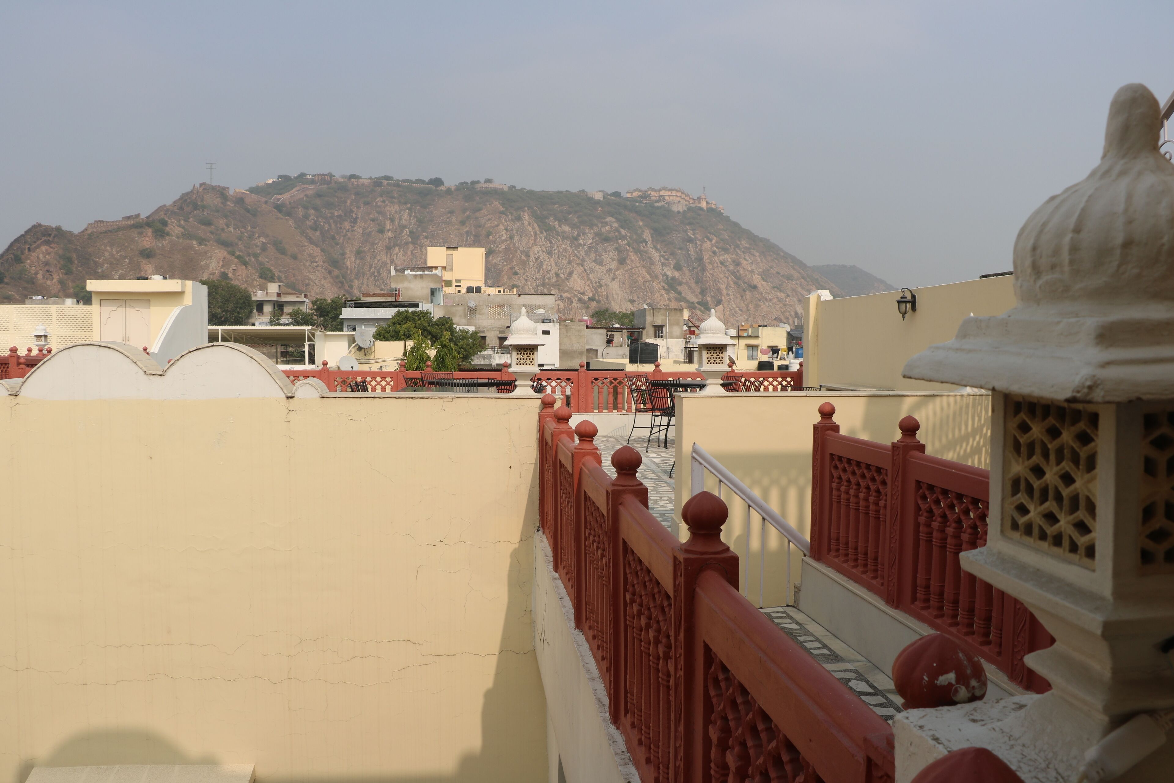 Ein Gebäude mit roter Brüstung und einem Berg im Hintergrund.