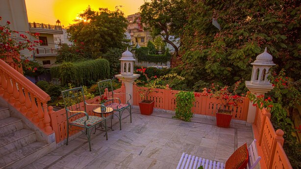 Ein Innenhof mit Sitzgelegenheit, Treppen und Topfpflanzen.