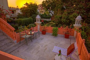 Un patio con zona de estar, escalones y plantas en macetas.