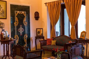 A traditional room with a sofa, chairs, a small table, and a decorative wall piece.