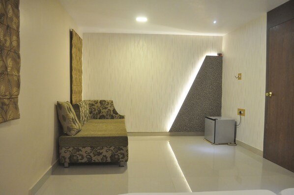 A modern room with a sofa, a small cabinet, and a door.