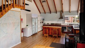 Una cocina moderna con vigas de madera, una isla grande y vistas al exterior.