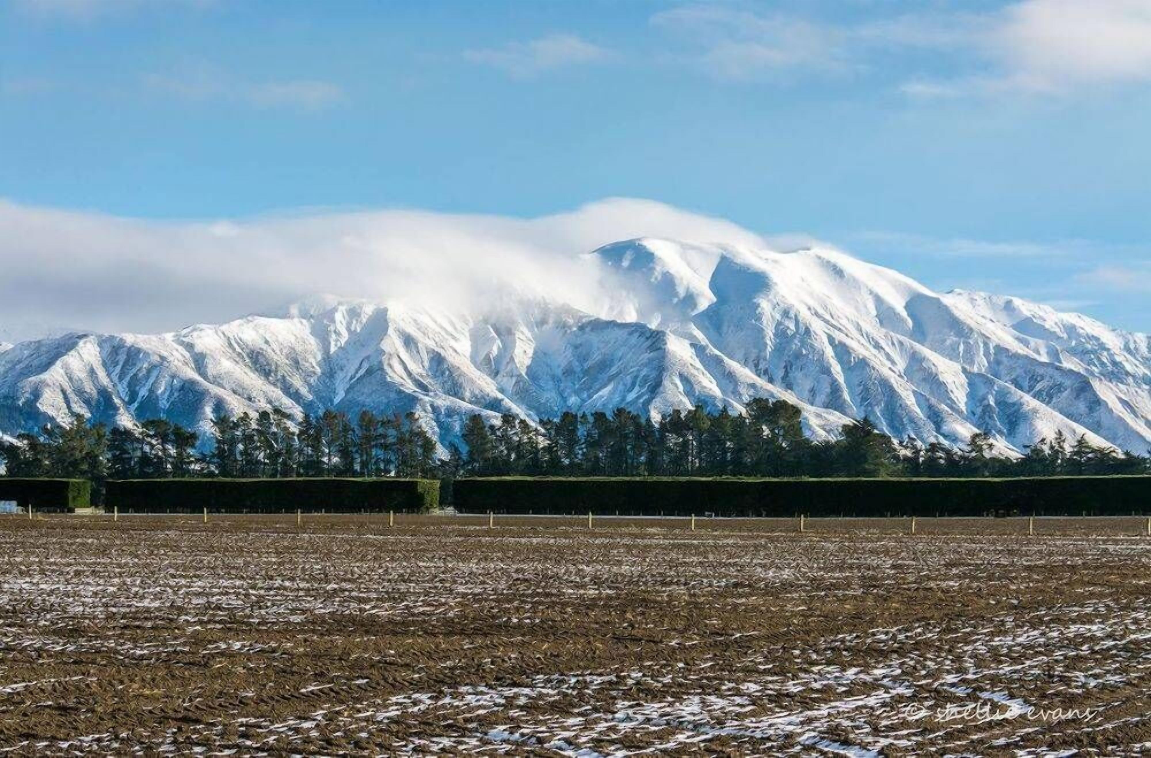 A snow-covered mountain range with a clear sky.