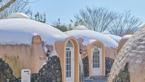 A snow-covered building with arched doorways and stone walls, labeled with room numbers A-9 and A-10.