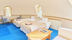 A hotel room with two beds, a desk, a chair, and a sofa.