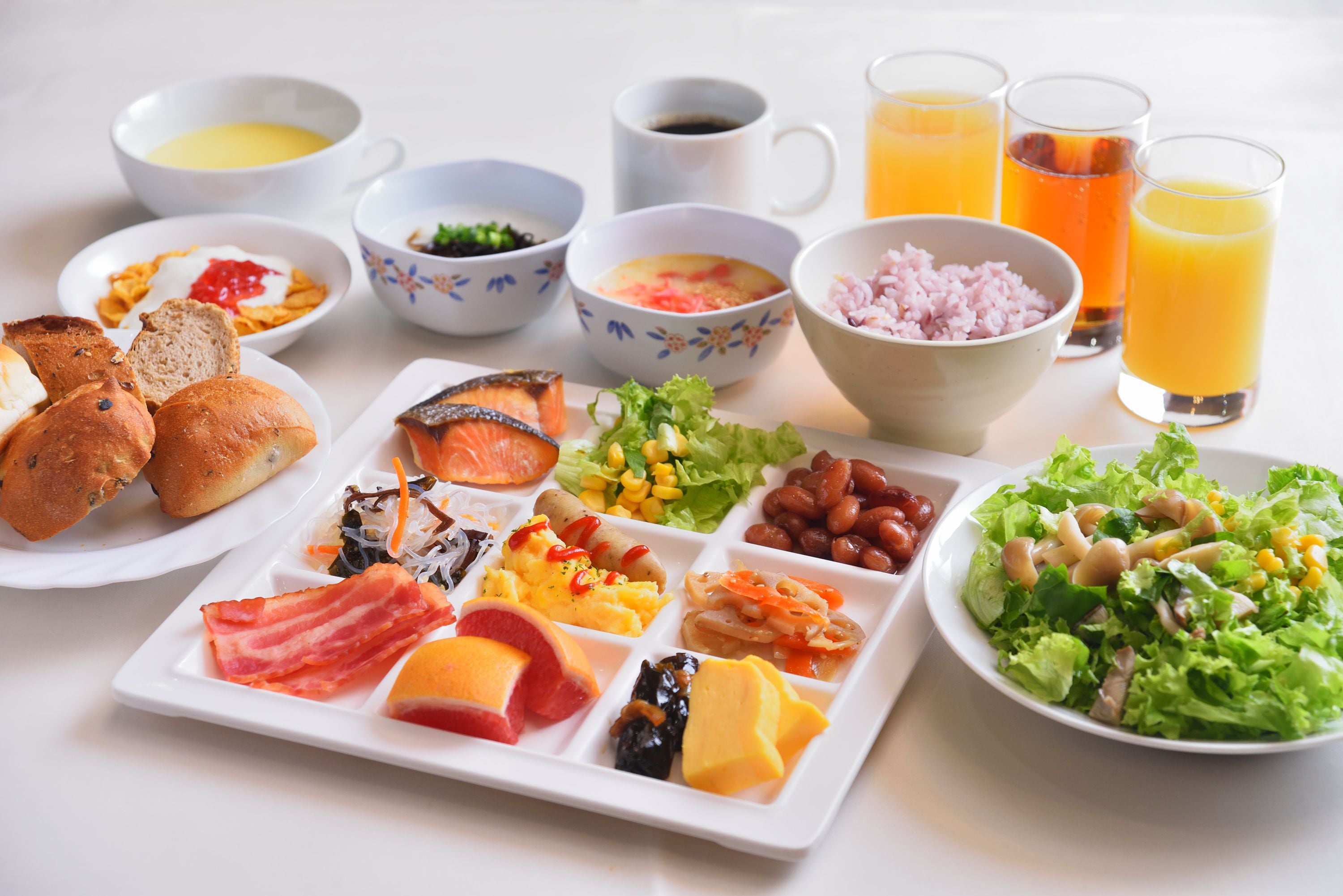 Un ricco buffet della colazione con piatti assortiti, bevande e un'insalata.