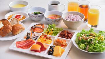 Un ricco buffet della colazione con piatti assortiti, bevande e un'insalata.