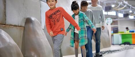 A group of people walking on a pathway in an indoor setting with a modern architectural design.