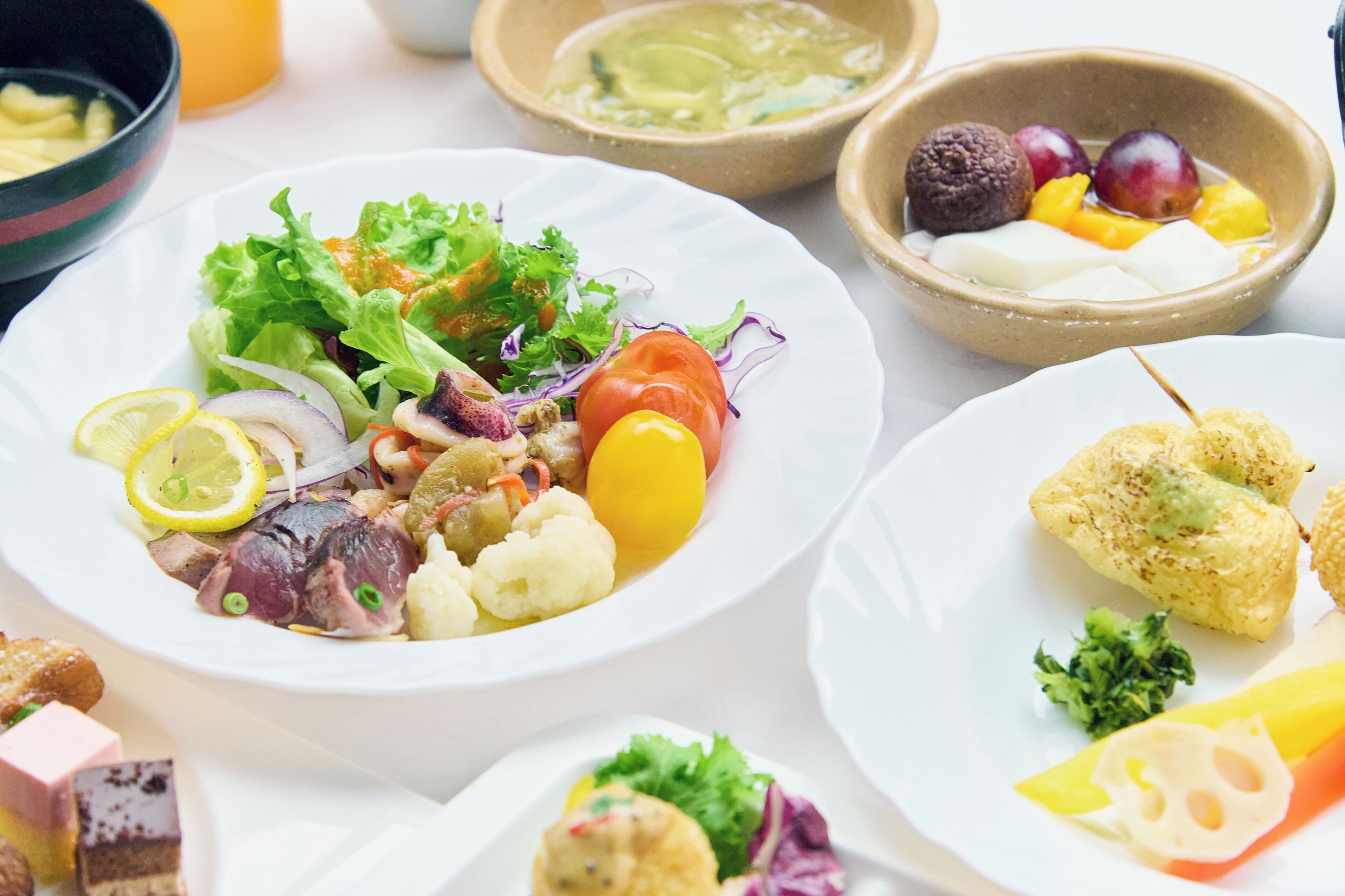 On vous proposera un assortiment de plats, notamment une salade composée de légumes et de poisson, une corbeille de fruits et une assiette de mets panés.