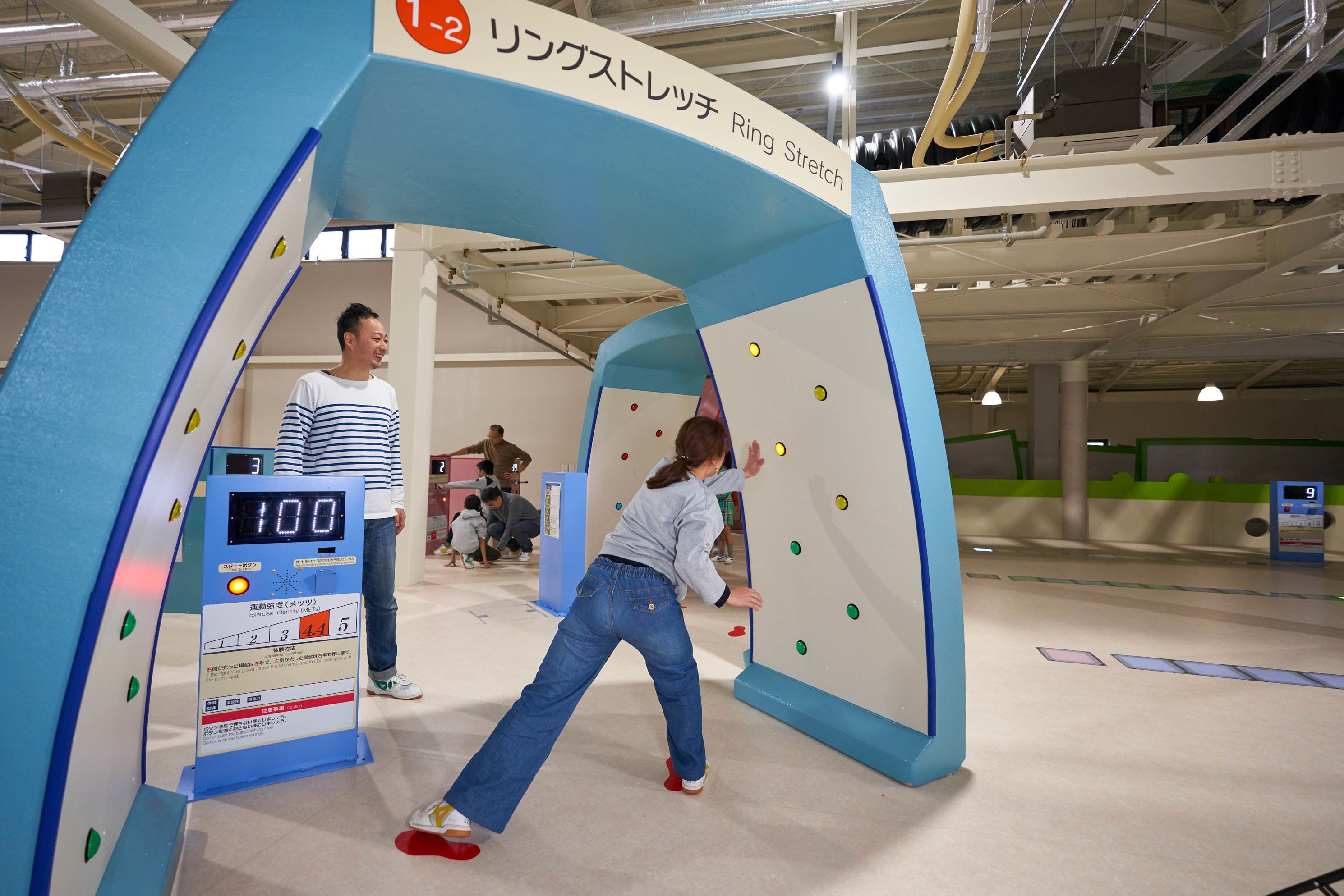 An indoor climbing wall with a digital timer and a score display.