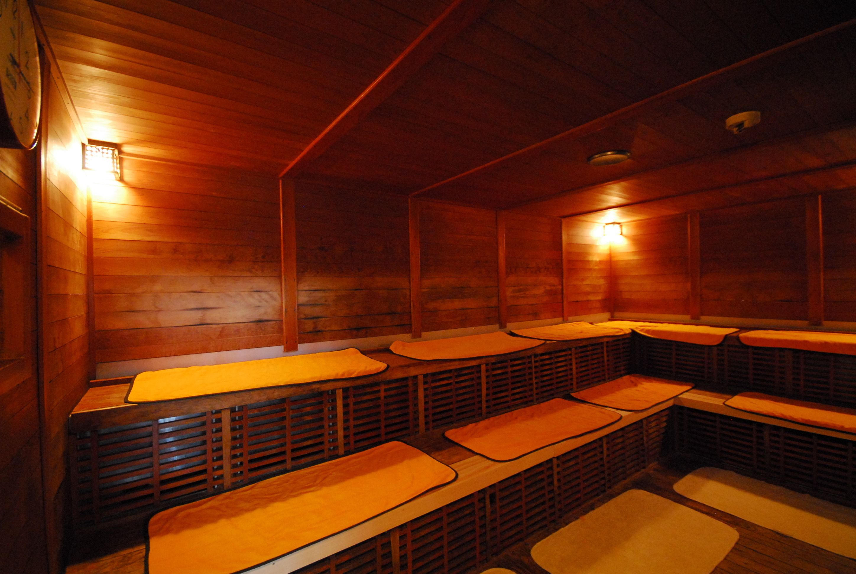 A sauna room with wooden benches and benches, equipped with benches and mats.