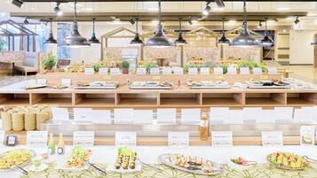 A buffet area with various food stations, wooden tables, and hanging pendant lights.