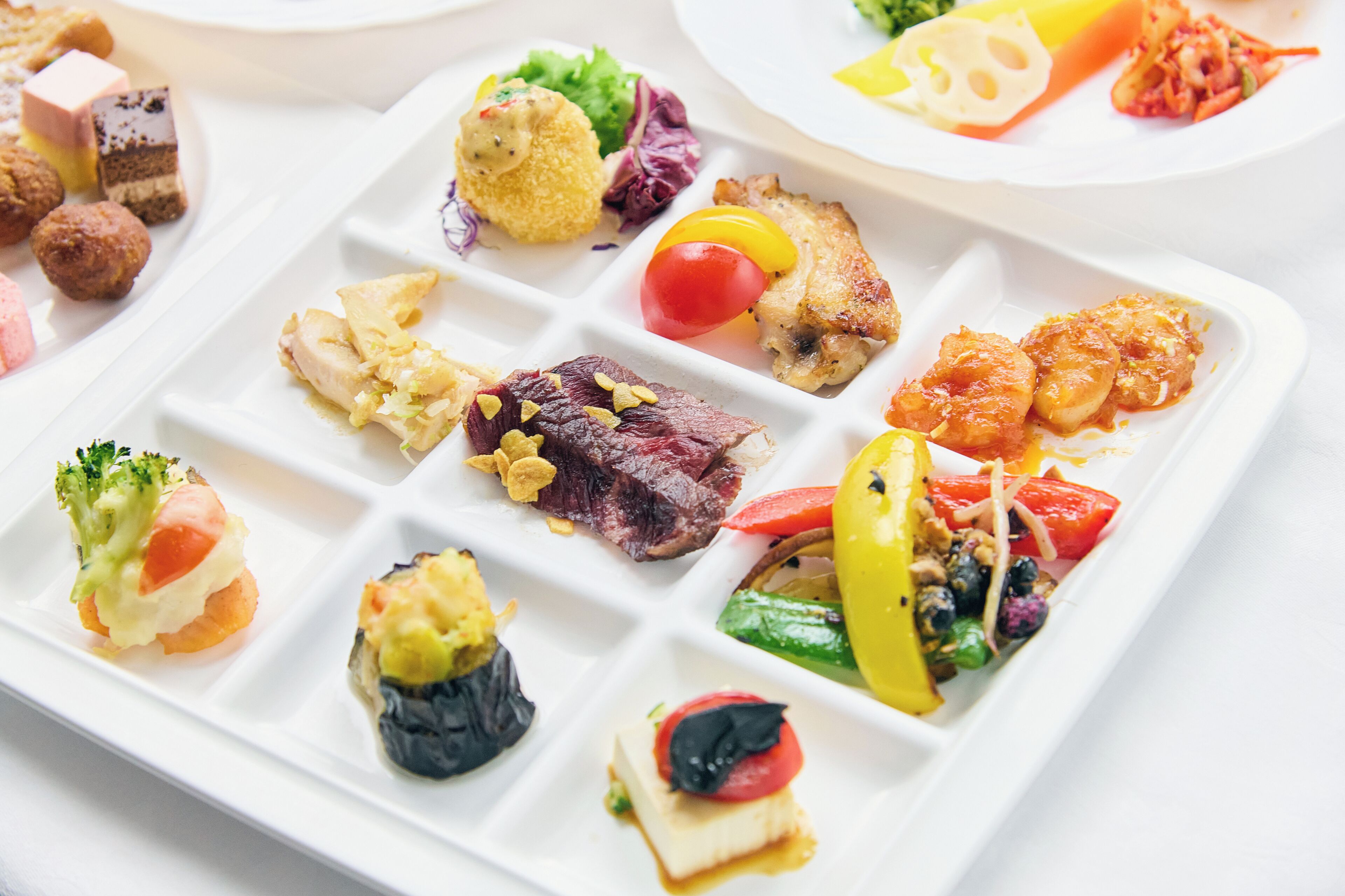 Un plato blanco con diversos alimentos, como carne, verduras y mariscos.