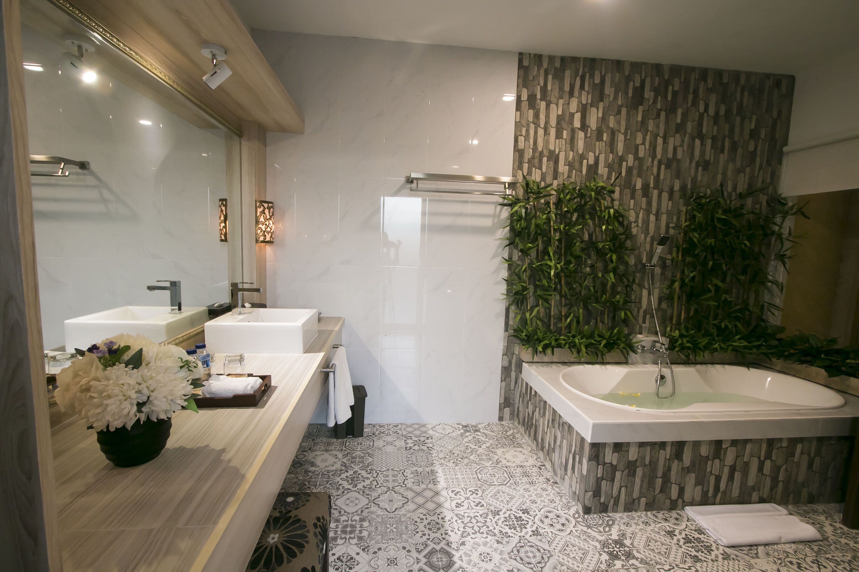 Een moderne badkamer met twee wastafels, een bad en een douche.