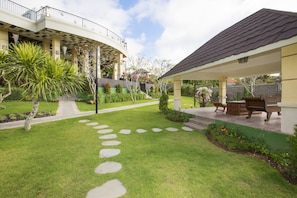 Ein angelegter Garten mit Terrassenbereich, Steintreppe und Gartenmöbeln.