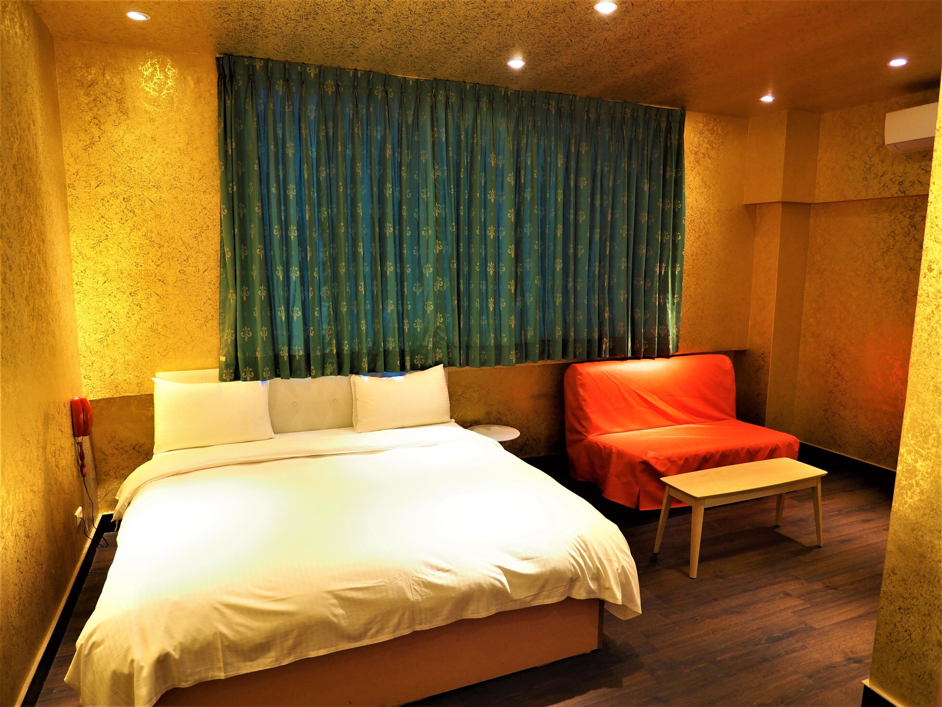 A hotel room with a large bed, a small table, and a chair.