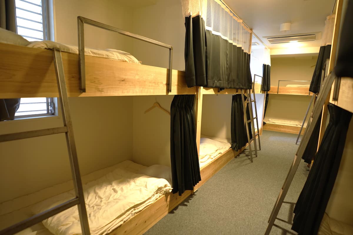 Un dormitorio con literas, una ventana y una escalera.