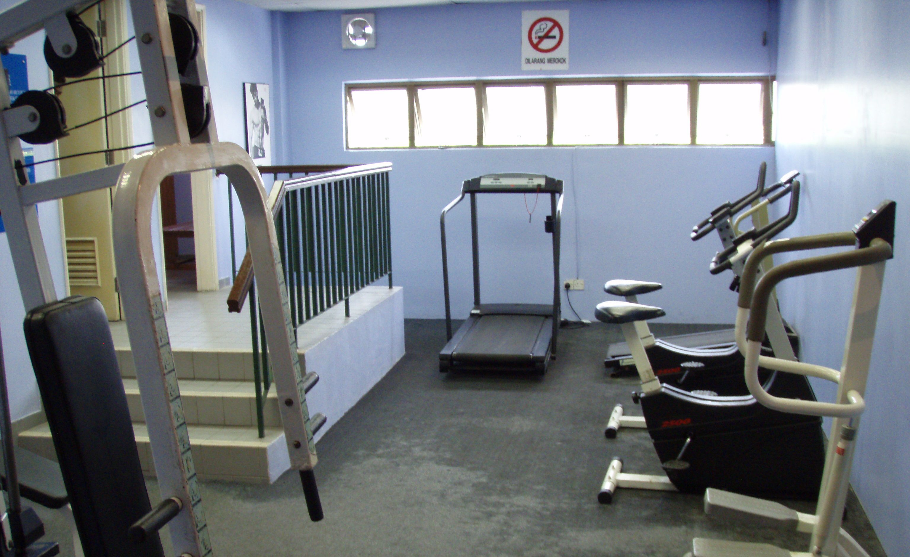 A gym with treadmills, weight machines, and a stair climber.