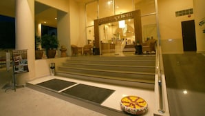 La entrada del Hotel People Place, con mostrador de recepción, zona de estar y una escalera que lleva a la entrada.
