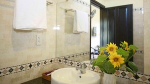 A bathroom with a sink, mirror, and towels. - Do River Homestay (Da Nang)