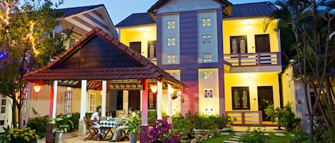 Vista frontal de la propiedad por la tarde o noche