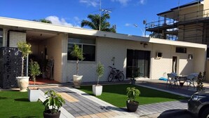 A modern two-story house with a covered patio, a bicycle, and a car parked in front. - Perth City Motel (Thornlie)