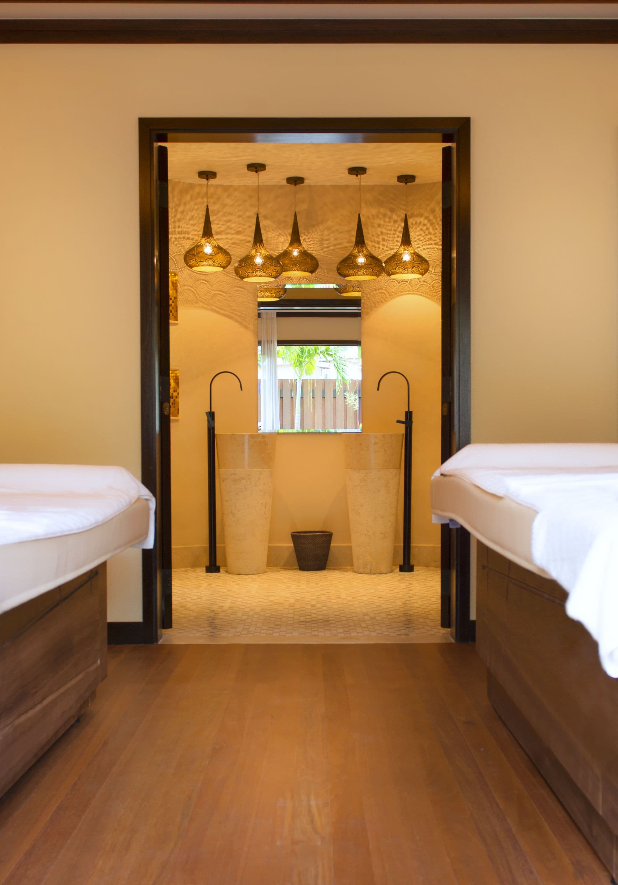 A hotel room with two beds, a large window, and a unique hanging light fixture.
