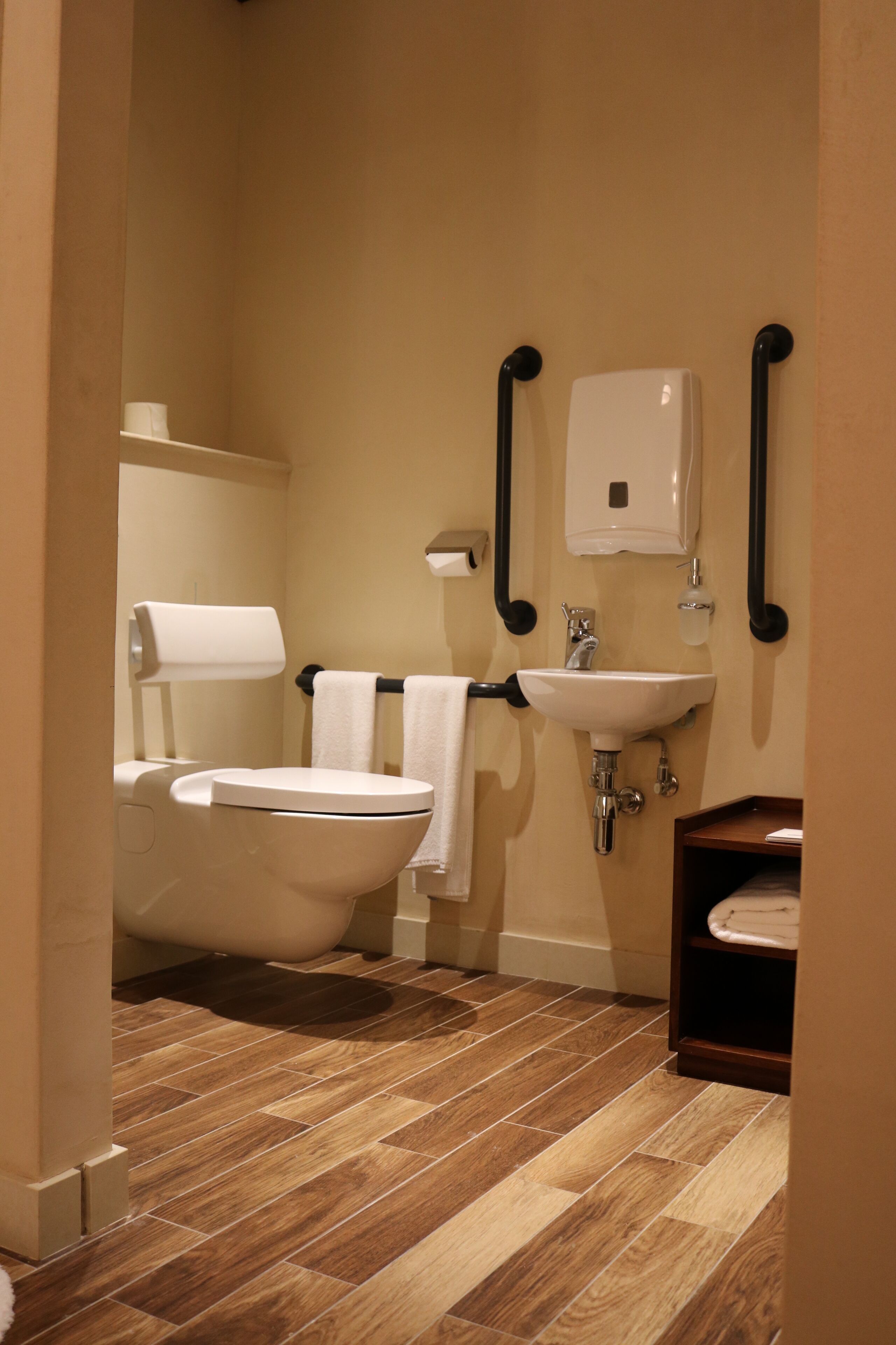 A bathroom with a toilet, bidet, sink, and hand dryer.