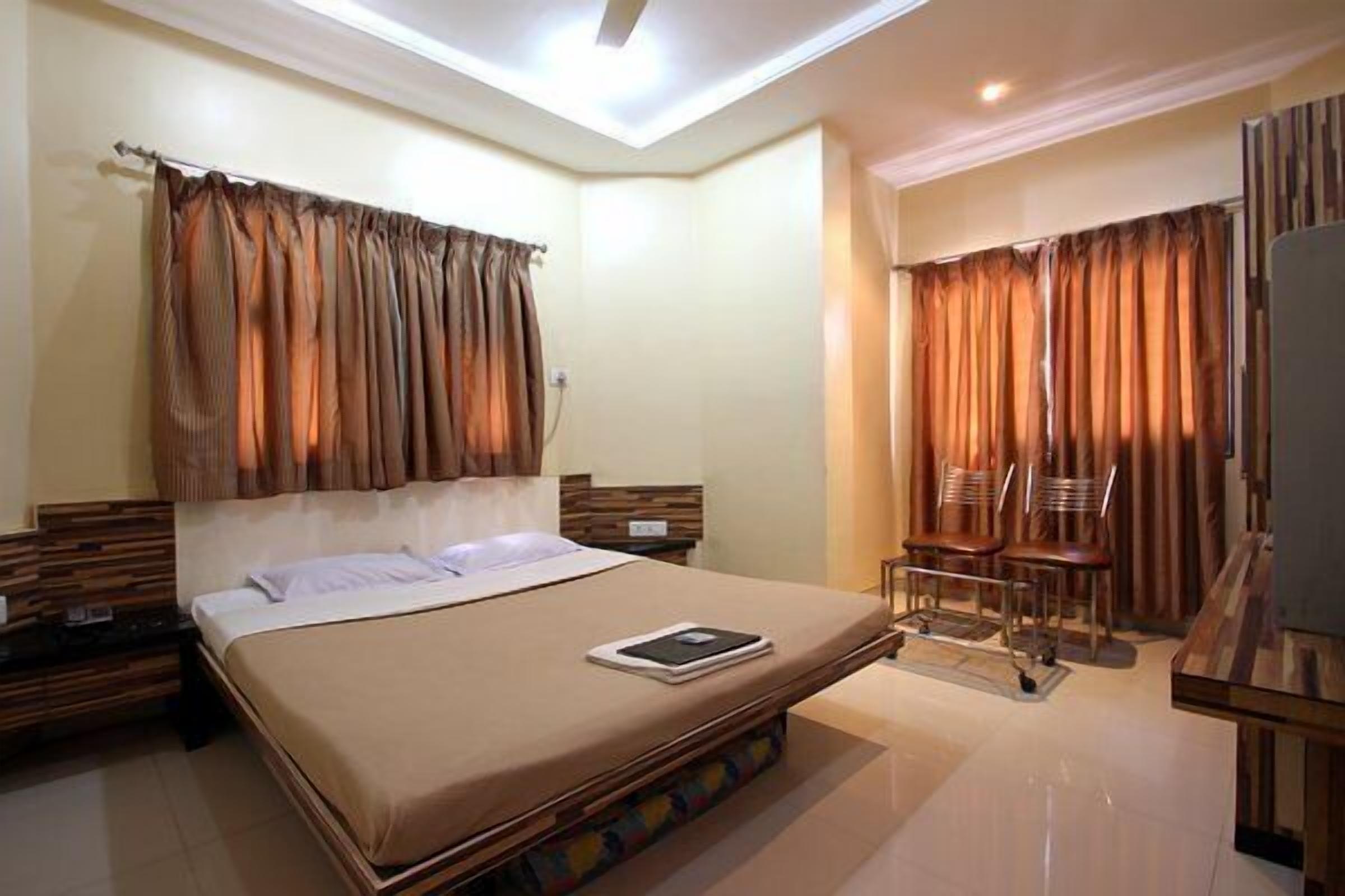 A hotel room with a bed, a desk, and a chair.