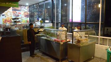 A restaurant kitchen with chefs preparing food, a display case with food items, and a sign reading "Dice Kitchen".