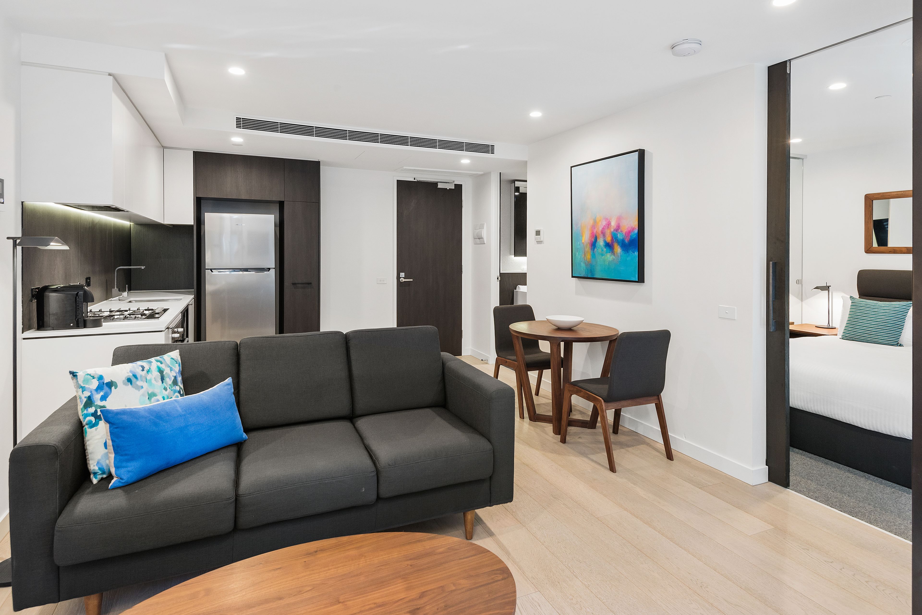 A modern living room with a sofa, coffee table, and dining area.