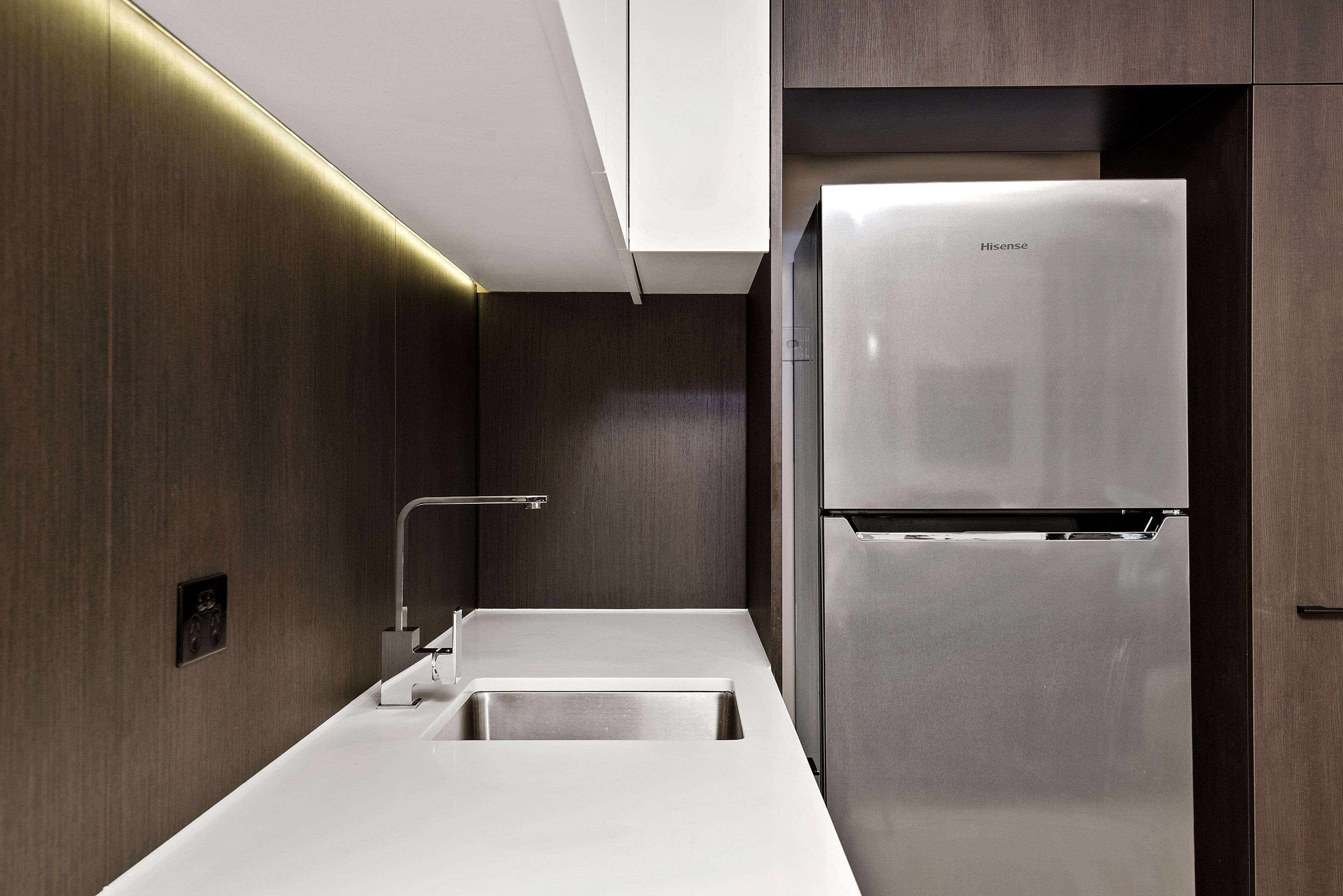 A modern kitchen with a stainless steel refrigerator, a sink, and a faucet.
