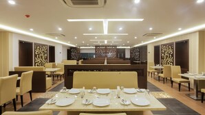Un restaurante con mesas dispuestas para comer, cabinas y una barra.