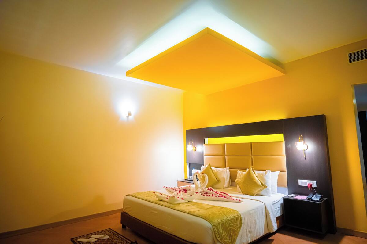 Een hotelkamer met een groot bed, een nachtkastje en een modern hoofdeinde.