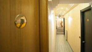 A hallway with wooden doors, a staircase, and a statue. - Hotel Bella Napoli (Naples)