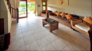 A spacious living area with a sofa set, a coffee table, and a staircase leading to an outdoor area.